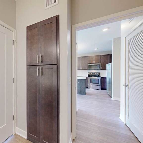 Thumbnail 25 of 27 A bathroom with a a door open to the living room, and a closed linen storage cabinet.