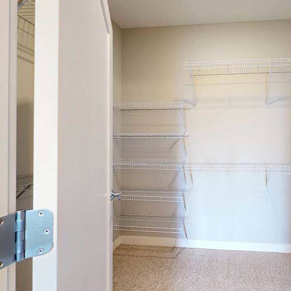 Thumbnail 18 of 27 An oversized walk-in closet with several built-in wire shelves.