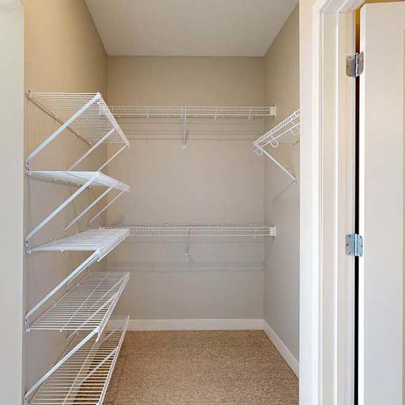 Thumbnail 21 of 27 An oversized walk-in closet with several built-in wire shelves.