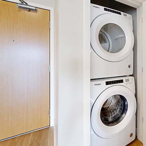 Thumbnail 27 of 27 A stacked full-sized washer and dryer in a laundry closet.