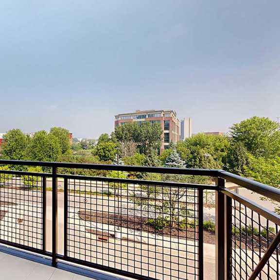 Thumbnail 13 of 29 A balcony with a metal railing and a view of the neighborhood.