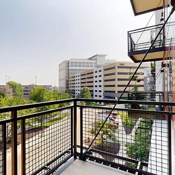 Thumbnail 12 of 29 A balcony with a metal railing and a view of the neighborhood.