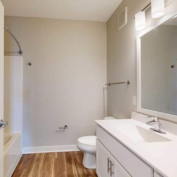 Thumbnail 27 of 29 A bathroom with a marble vanity, white wooden cabinets, and a tub shower.