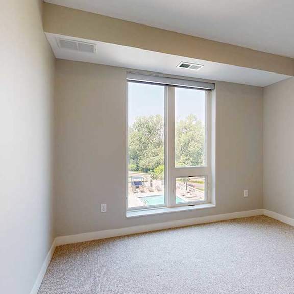 Thumbnail 26 of 29 A carpeted bedroom with a floor-to-ceiling window.