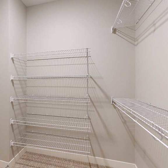 Thumbnail 20 of 29 An oversized walk-in closet with several built-in wire shelves.