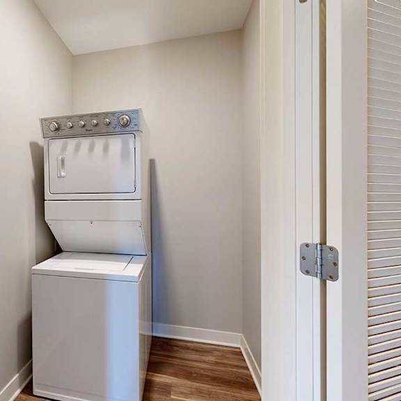 Thumbnail 23 of 29 A stacked full-sized washer and dryer in a laundry closet.