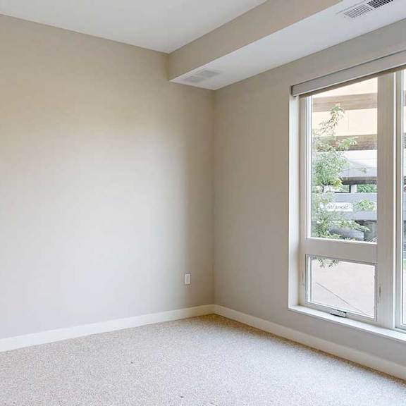 Thumbnail 26 of 29 A carpeted bedroom with a floor-to-ceiling window.