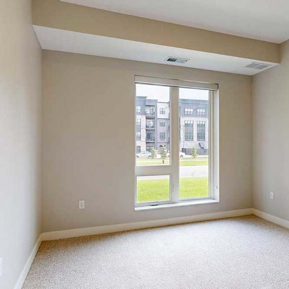 Thumbnail 18 of 29 A carpeted bedroom with a floor-to-ceiling window.