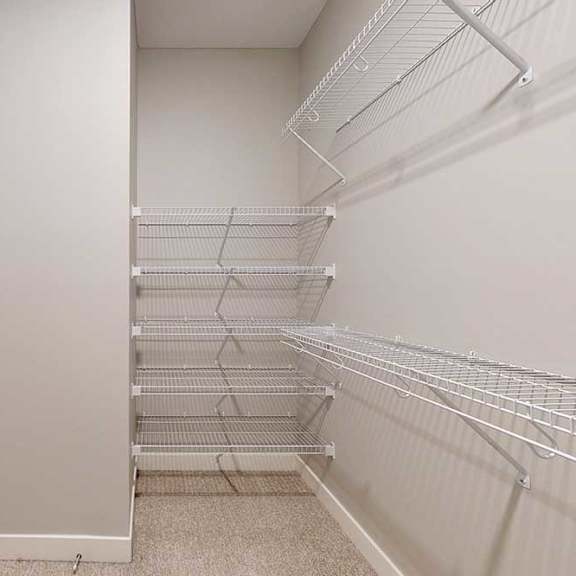 Thumbnail 24 of 29 An oversized walk-in closet with several built-in wire shelves.