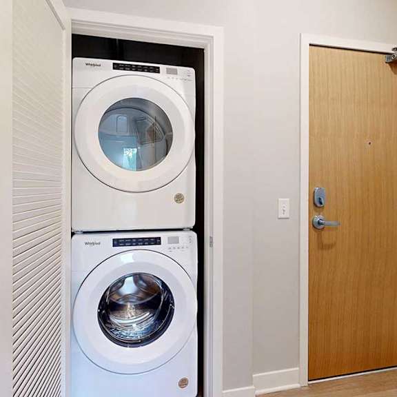 Thumbnail 5 of 29 A stacked full-sized washer and dryer in a laundry closet.