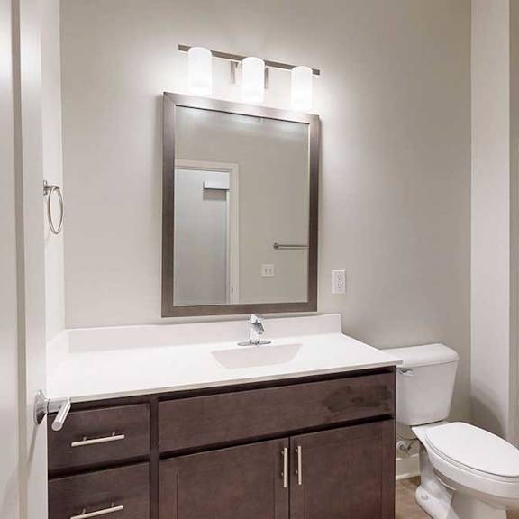 Thumbnail 10 of 21 A bathroom with a marble vanity, dark wooden cabinets, and a tub shower.