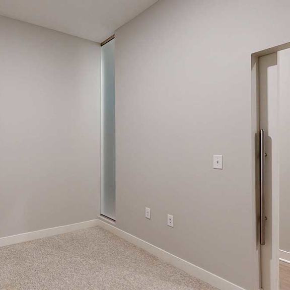 Thumbnail 6 of 21 A carpeted sleeping area with a barn door.
