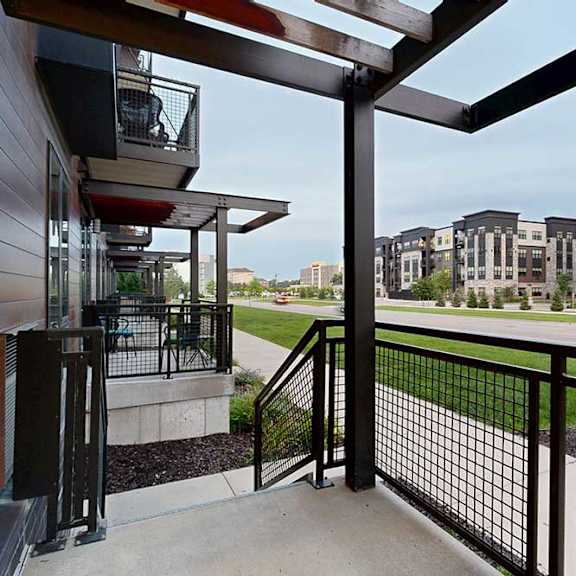 Thumbnail 20 of 21 A patio with a black metal railing, a pergola covering, and a view of the neighborhood.