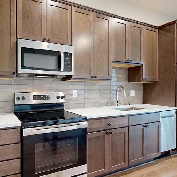 Thumbnail 6 of 16 A kitchen with wooden cabinets and a stainless steel appliances