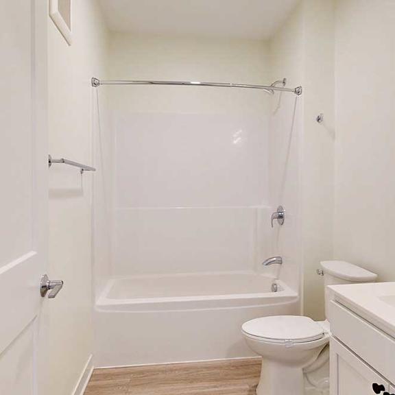 Thumbnail 16 of 17 A white bathroom with a toilet, sink, and shower/tub combo