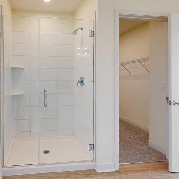 Thumbnail 21 of 23 A white bathroom with a glass shower stall.