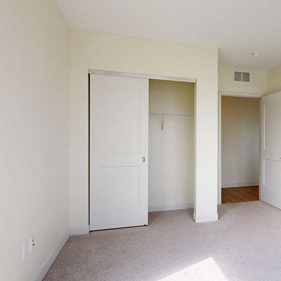 Thumbnail 20 of 23 A room with two white doors and a carpeted floor.