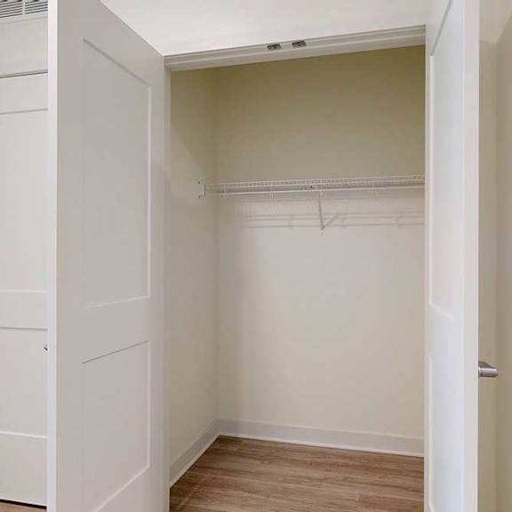 Thumbnail 3 of 23 A white closet with a door and a shelf.