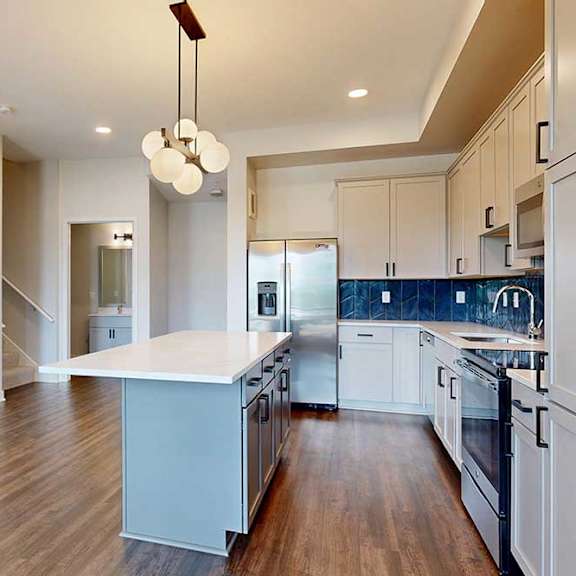 Thumbnail 12 of 31 A modern kitchen with a center island and stainless steel appliances.
