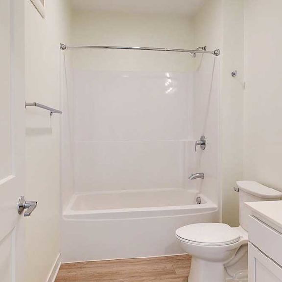 Thumbnail 18 of 19 A white bathroom with a toilet, sink, and bathtub.