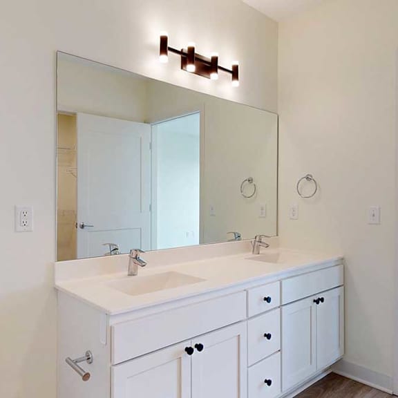 Thumbnail 23 of 26 A white bathroom with a sink, mirror, and toilet.