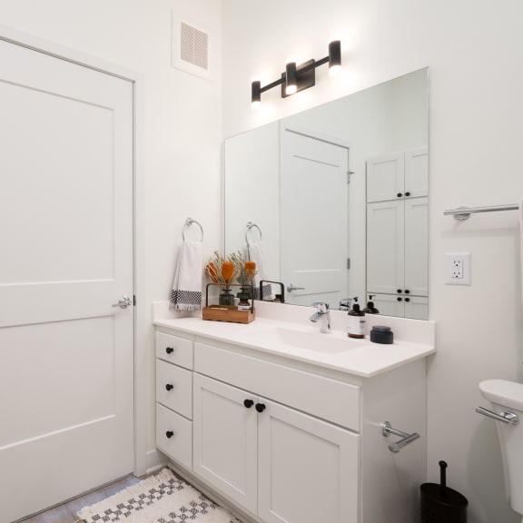 Thumbnail 8 of 24 White bathroom vanity with large mirror and towel hanging on rack