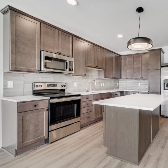 Thumbnail 2 of 8 Spacious open kitchen with matching steel appliances and plenty of cabinet storage space at The Rowan in Eagan Minnesota