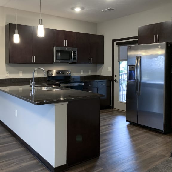 Thumbnail 10 of 23 kitchen with dark brown cabinets and L shaped counter at the villas at mahoney park