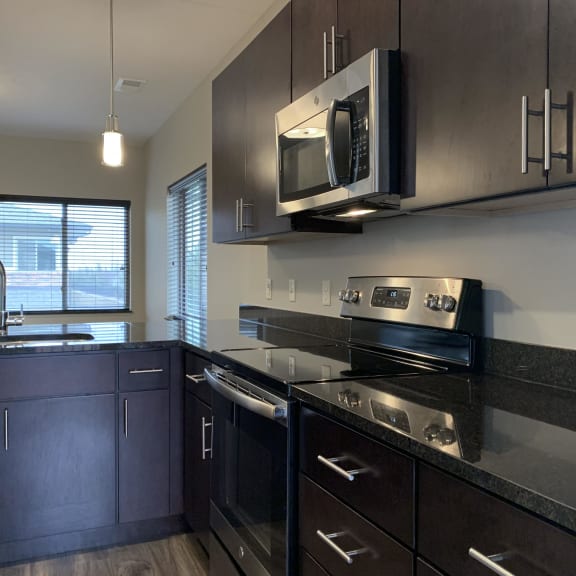 Thumbnail 8 of 23 Dark brown kitchen cabinets with matching stainless steel appliances at the villas at mahoney park