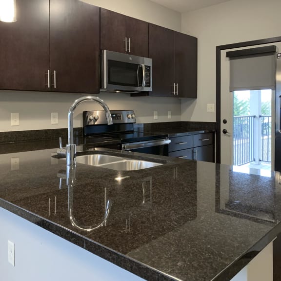 Thumbnail 4 of 23 Kitchen with dark brown cabinets and matching stainless steel appliances at the villas of mahoney park