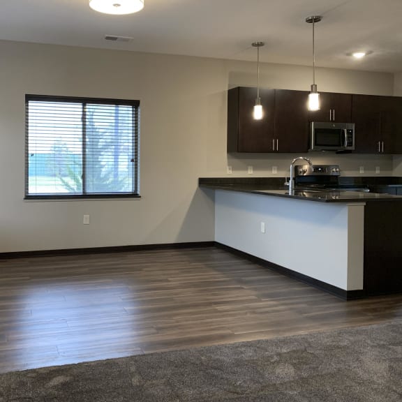 Thumbnail 5 of 23 Dining next to kitchen with hard wood style flooring at the villas at mahoney park