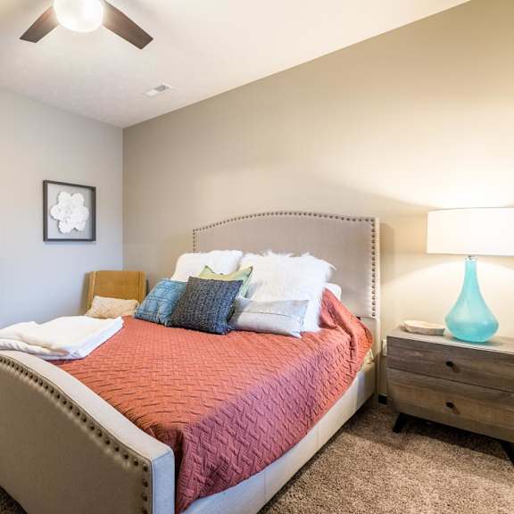 Thumbnail 13 of 21 A bedroom with a large bed and a ceiling fan.
