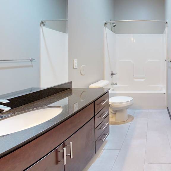 Thumbnail 9 of 9 A bathroom with a toilet, sink, and shower.