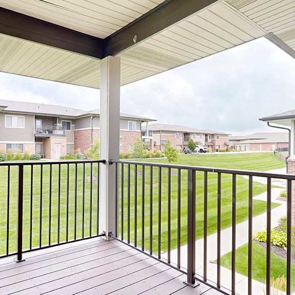 Thumbnail 15 of 25 A corner balcony with a metal railing and a view of the neighborhood.