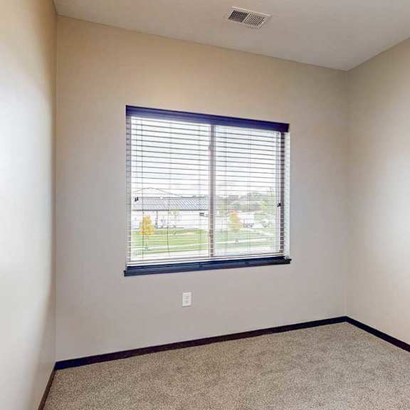 Thumbnail 19 of 25 A carpeted den space with a window.