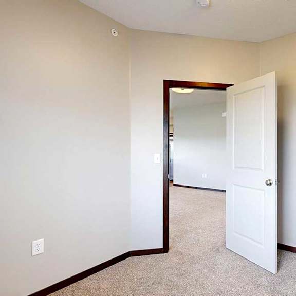 Thumbnail 18 of 25 A carpeted den space with a door open to the living room.