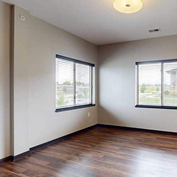 Thumbnail 9 of 25 A dining area with large windows and hardwood-style flooring next to the kitchen.