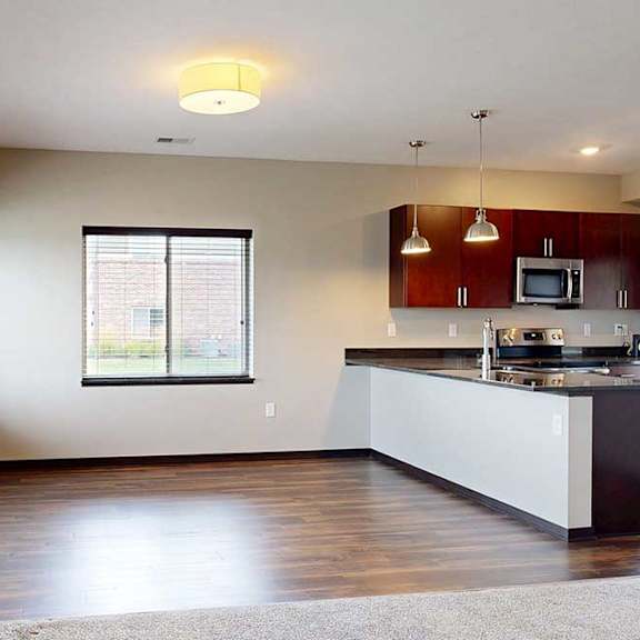 Thumbnail 10 of 25 A dining area with large windows and hardwood-style flooring next to the kitchen.