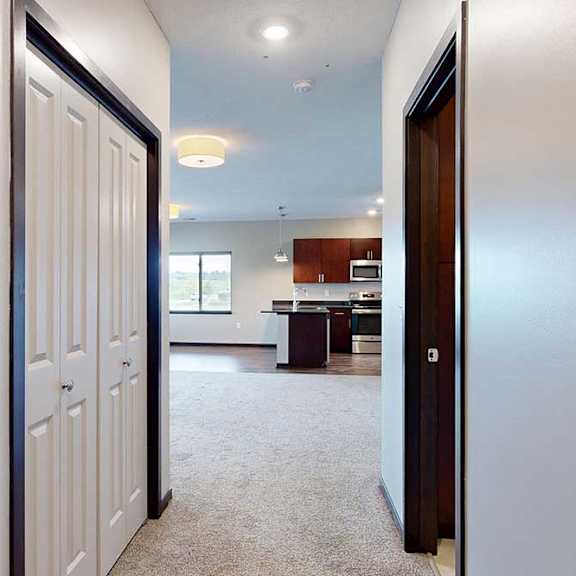 Thumbnail 5 of 25 A short hallway with a coat closet, and a doorway to the attached bathroom.