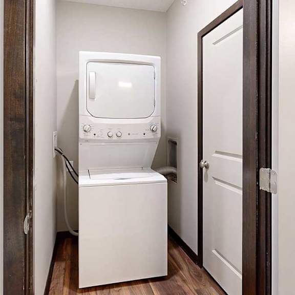 Thumbnail 25 of 25 A stacked washer and dryer in a laundry room.