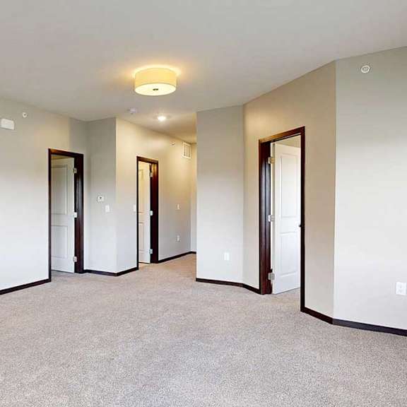 Thumbnail 20 of 25 A carpeted living room connected to a den space and bedroom.