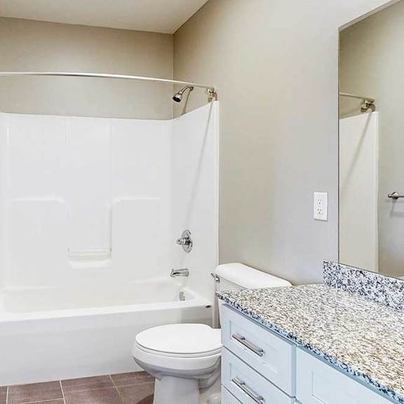 Thumbnail 26 of 26 A bathroom with a granite vanity, white wooden cabinets, and a tub shower.