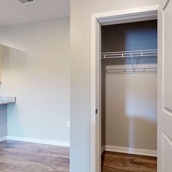 Thumbnail 9 of 26 A coat closet with a built-in wire shelf, at the top of the stairway.