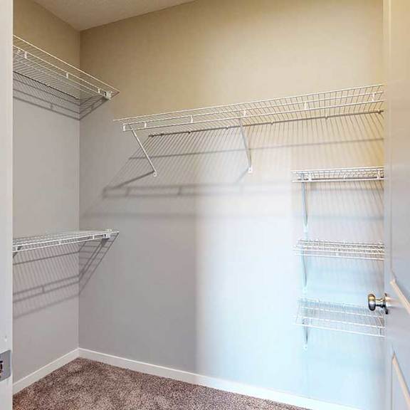 Thumbnail 23 of 26 An oversized walk-in closet with several built-in wire shelves.
