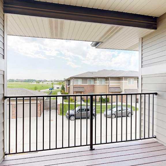 Thumbnail 21 of 26 A balcony with a black metal railing and a view of the neighborhood.