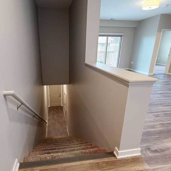 Thumbnail 8 of 26 A staircase the connects the living area down to the front entry.