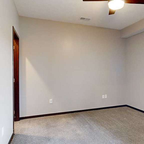 Thumbnail 20 of 24 A carpeted bedroom with a ceiling fan and a window.