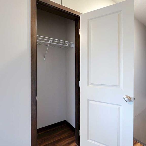 Thumbnail 6 of 24 A coat closet with a built-in wire shelf.
