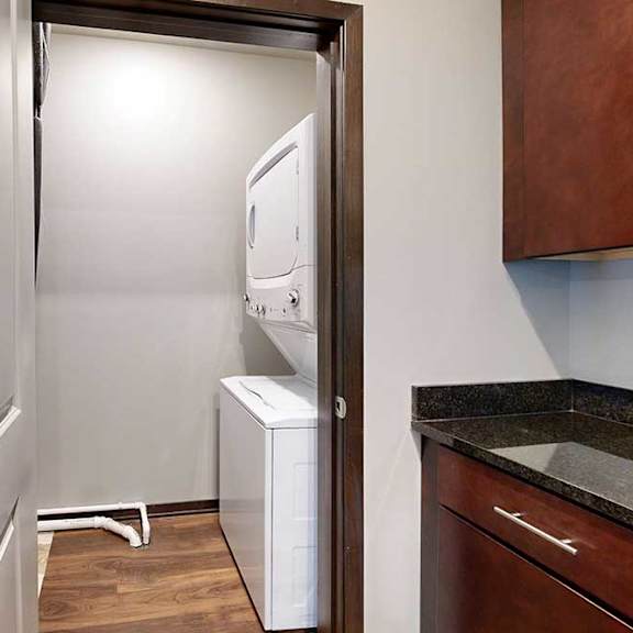 Thumbnail 10 of 24 A stacked washer and dryer in a room off the kitchen.