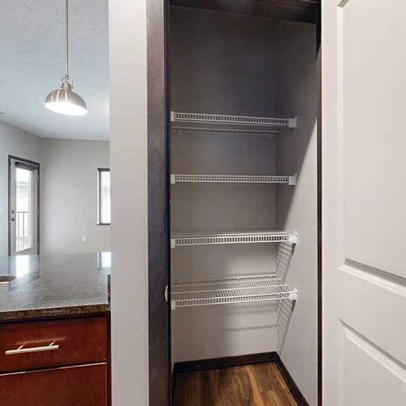 Thumbnail 9 of 24 A kitchen pantry with several built-in wire shelves.
